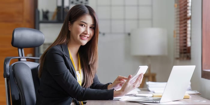 Asian Business person makes analysis and research financial report at office, analyzes profits. Accountant checks status of financial.