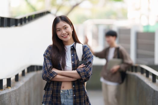 Young Asian woman college student with friends at outdoors. College student working on the college campus, education, school, study.