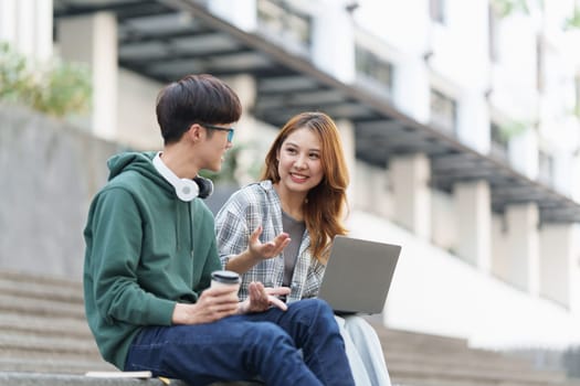 Young Asian woman college student with friends at outdoors. College student working on the college campus, education, school, study.