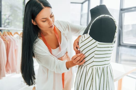 Measuring clothes. Seamstress is in her office.