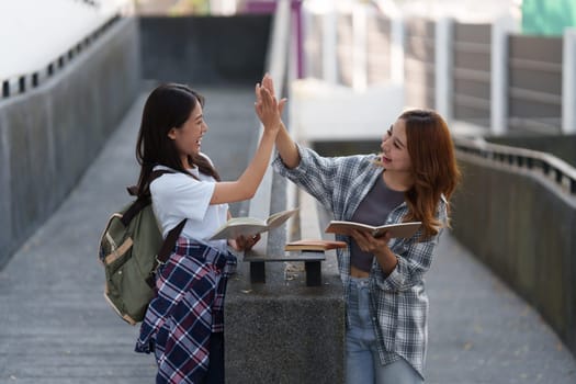 Young Asian woman college student with friends at outdoors. College student working on the college campus, education, school, study.