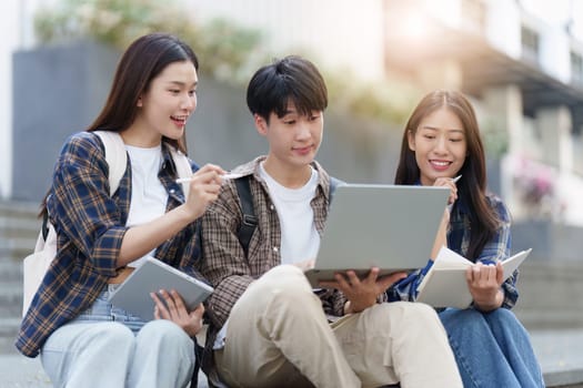 Young Asian woman college student with friends at outdoors. College student working on the college campus, education, school, study.