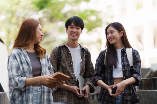 Young Asian woman college student with friends at outdoors. College student working on the college campus, education, school, study.