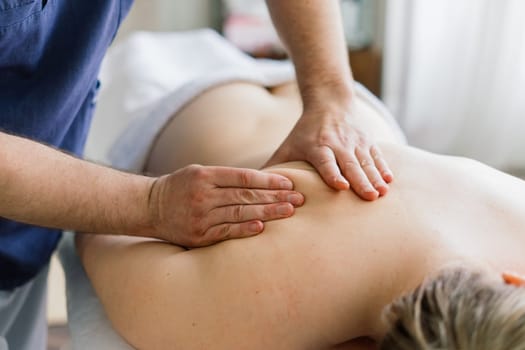 Young fat woman getting massage treatment in a day spa cabinet.