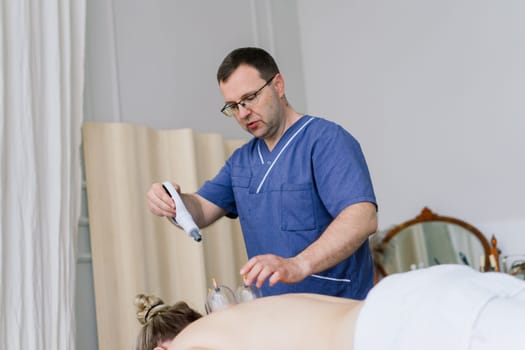 Young fat woman getting massage treatment in a day spa cabinet.