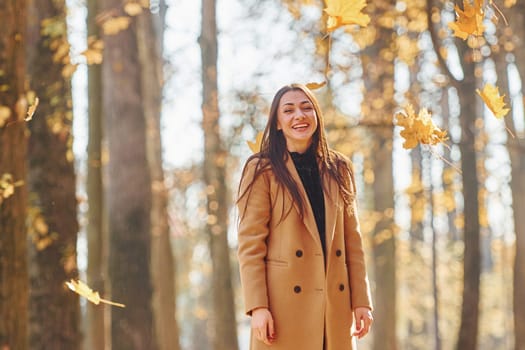 Having good mood. Woman in coat have walk in the autumn forest.