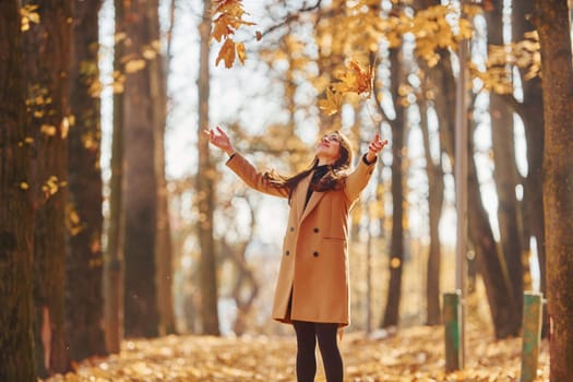 Having good mood. Woman in coat have walk in the autumn forest.