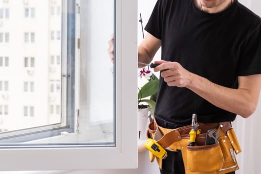 male industrial builder worker at window installation in building construction site. High quality photo