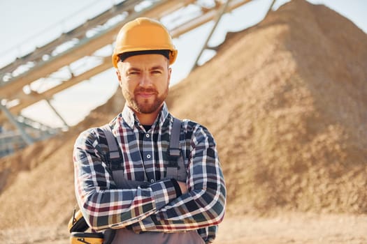 Positive man. Construction worker in uniform is on the quarry.