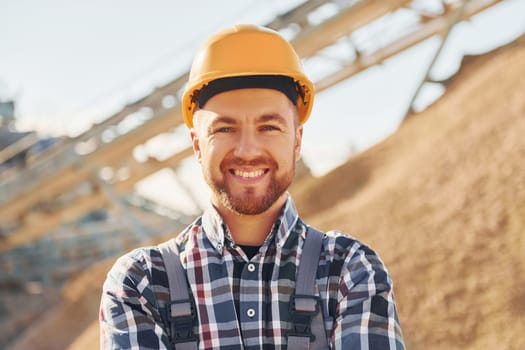 Positive man. Construction worker in uniform is on the quarry.