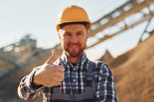 Positive man. Construction worker in uniform is on the quarry.