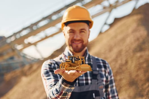 Positive man. Construction worker in uniform is on the quarry.