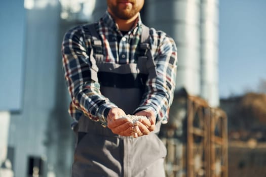 Professional worker is outside. Construction worker in uniform is outdoors near the factory.