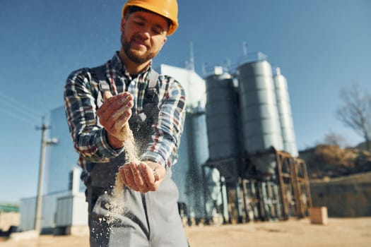 Construction worker in uniform is outdoors near the factory.