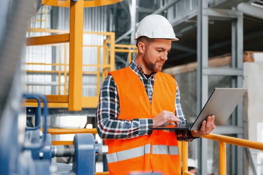 Professional construction worker in uniform is in the factory.