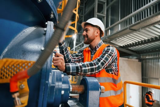 Professional construction worker in uniform is in the factory.