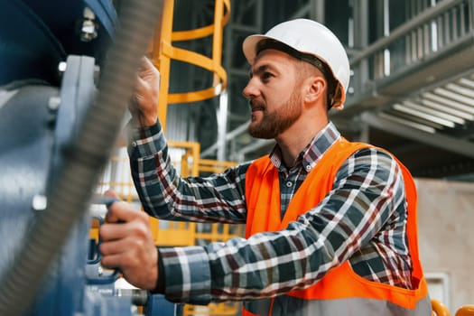 Professional construction worker in uniform is in the factory.