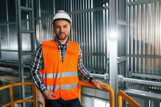 Professional construction worker in uniform is in the factory.