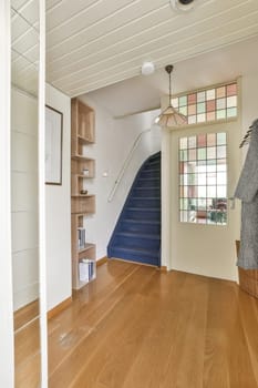 a living room with wood flooring and white walls, an open staircase leads up to the second floor in this house