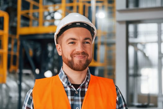 Portrait of construction worker in uniform is in the factory.