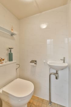a small bathroom with white tiles on the walls, and a toilet in the corner next to the sink area