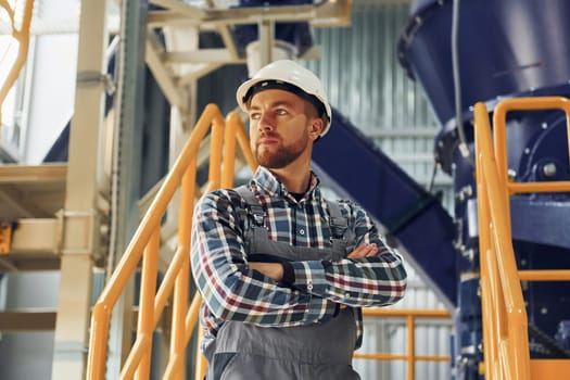 Engineer is indoors. Construction worker in uniform is in the factory.