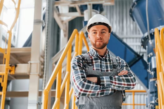 Engineer is indoors. Construction worker in uniform is in the factory.