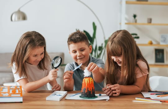 Working on the volcano project. Kids having fun in the domestic room at daytime together.