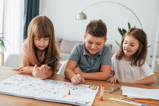 Playing game together. Kids having fun in the domestic room at daytime.