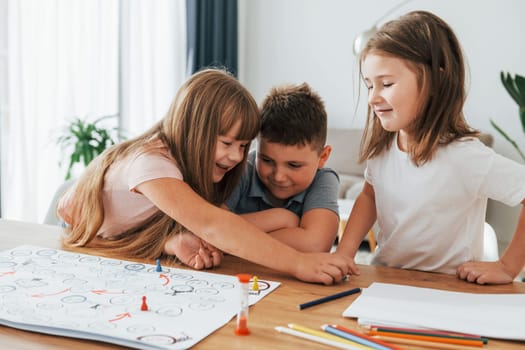 Playing game together. Kids having fun in the domestic room at daytime.