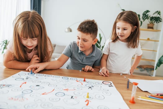 Playing game together. Kids having fun in the domestic room at daytime.