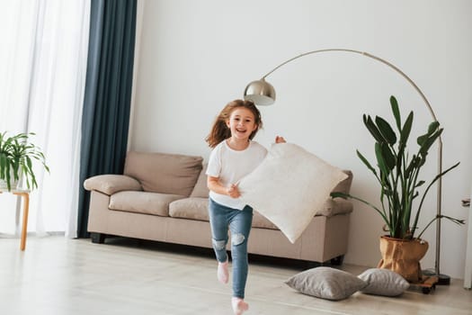 Little girl is having fun in the domestic room at daytime.