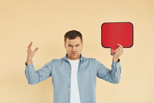 Angry and mad. Man standing in the studio with empty signs for the text.