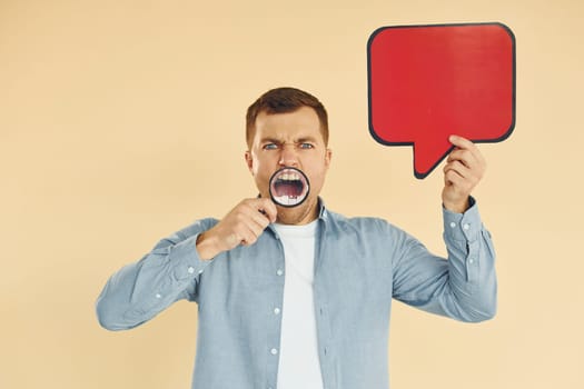 Angry and mad. Man standing in the studio with empty signs for the text.