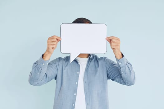 In casual clothes. Man standing in the studio with empty signs for the text.