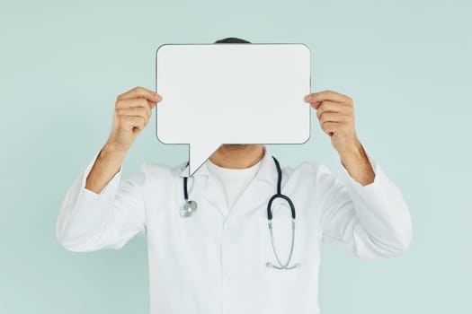 Young doctor. Man standing in the studio with empty signs for the text.