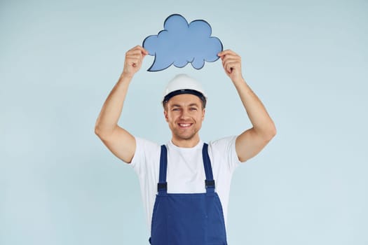 In white protective hat. Man standing in the studio with empty signs for the text.