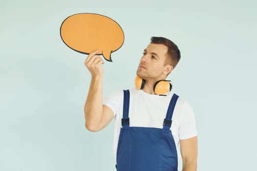 With big headphones on neck. Man standing in the studio with empty signs for the text.