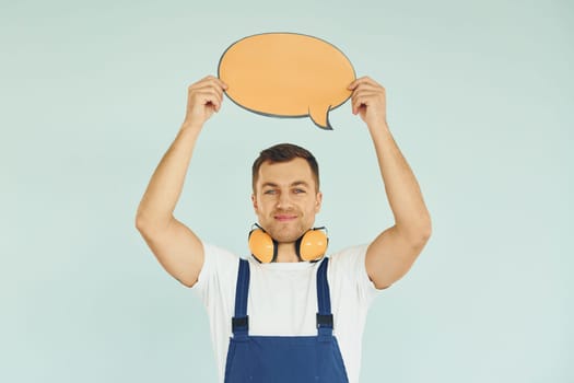 With big headphones on neck. Man standing in the studio with empty signs for the text.