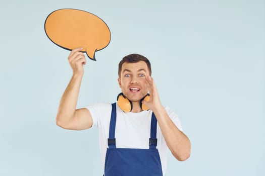 With big headphones on neck. Man standing in the studio with empty signs for the text.