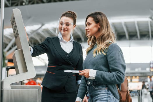 Using terminal. Young female tourist is in the airport at daytime.