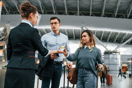 Checking documents at the entrance. Young couple is in the airport together.