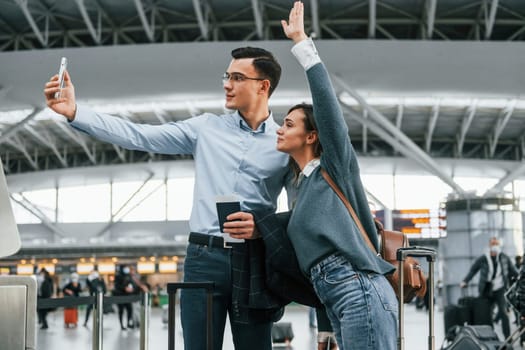 Making selfie. Young couple is in the airport together.