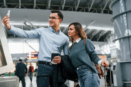 Making selfie. Young couple is in the airport together.