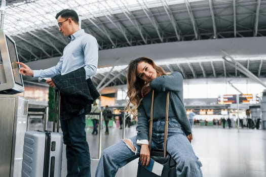 Woman is tired. Young couple is in the airport together.