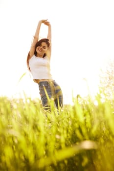 a woman on a bright sunny summer day standing in a yellow field. High quality photo