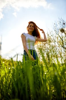 happy woman dancing in high grass field, bottom view. High quality photo