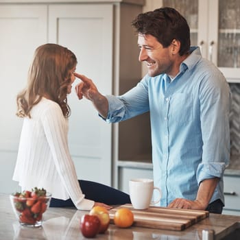 Are you going to stay this cute forever. a happy little girl chatting with her father while sitting on the kitchen counter at home