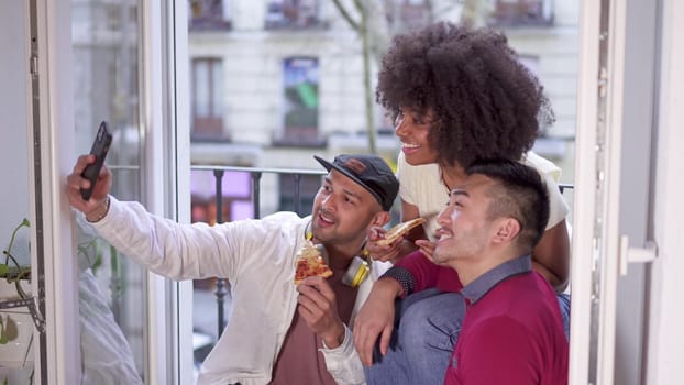 Slow motion video of a group of happy multiethnic friends taking a selfie while smiling on the balcony