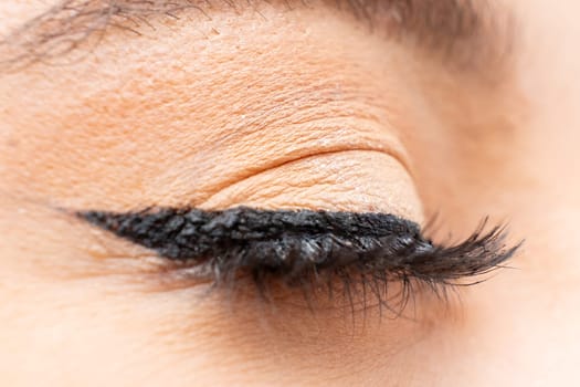 Close up of womans eye with perfect black eyeliner and long eyelashes.